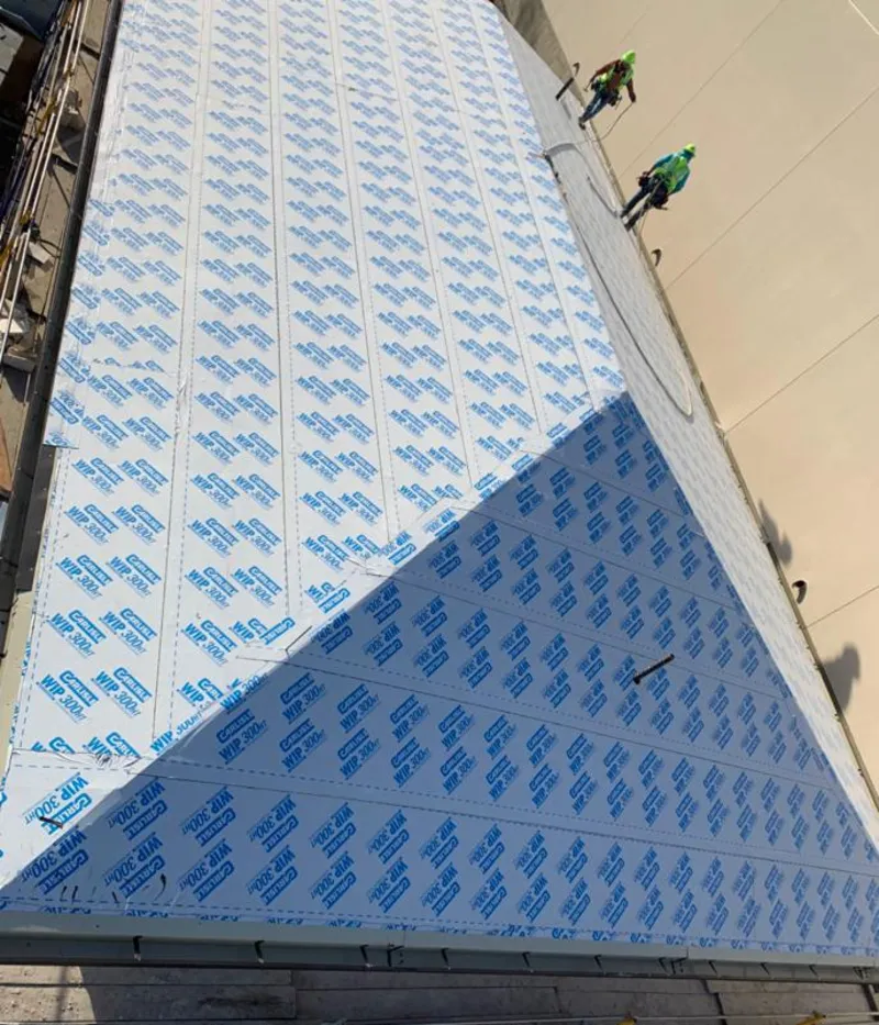 Professional roofers installing underlayment on a metal roof in Lyon